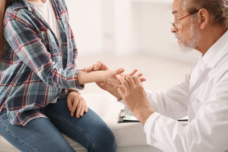 医生在门诊检查患者手部关节